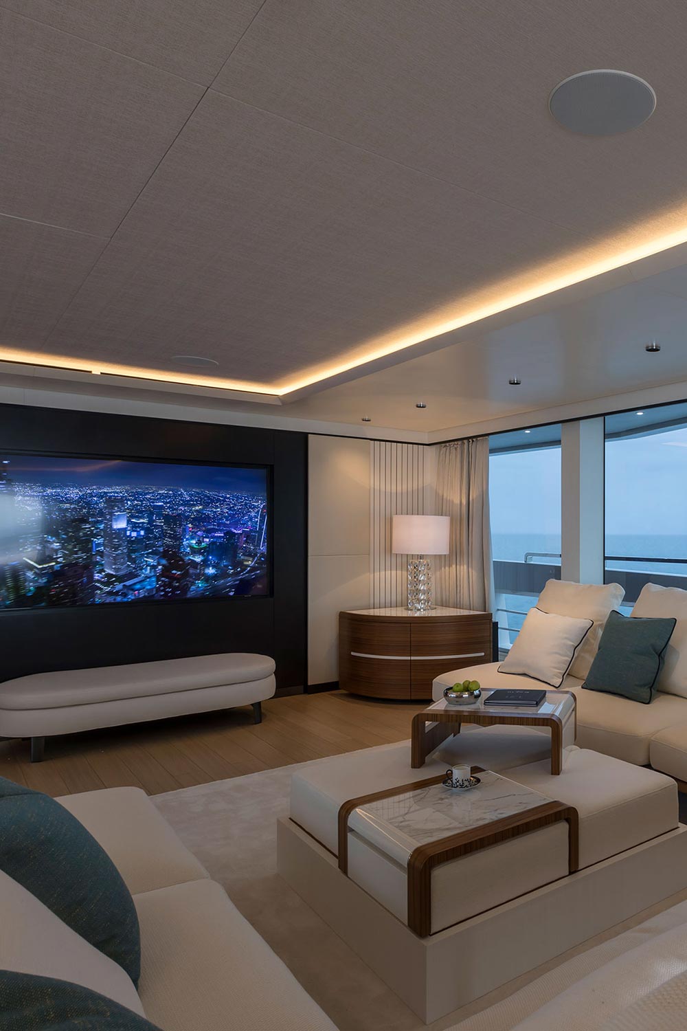 Luxury yacht cabin interior featuring comfortable seating, a media display, and an ocean view