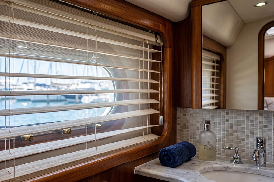Horizontal sheer blinds on a boat bathroom window next to a marble vanity