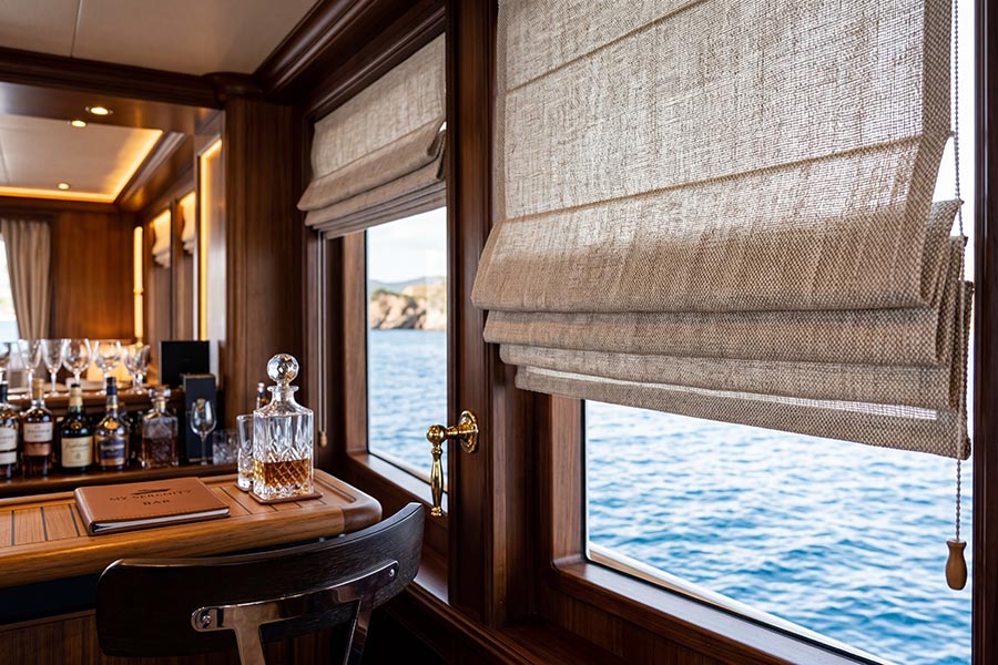 Textured linen Roman shades stacked over wooden windows with an ocean view